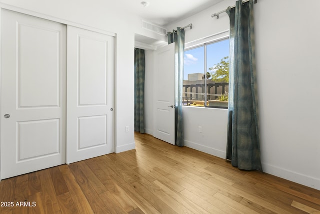 3131 N Central Ave Unit 3009, Phoenix, AZ 85012 - unfurnished bedroom with baseboards, wood finished floors, and a closet