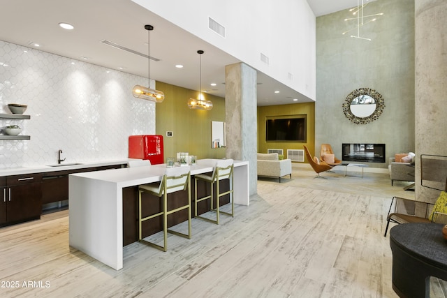3131 N Central Ave Unit 3009, Phoenix, AZ 85012 - bar area featuring a high ceiling, light wood-type flooring, a sink, and pendant lighting