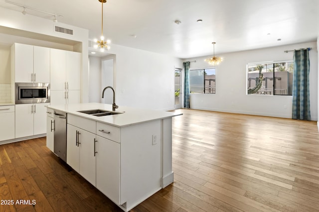 3131 N Central Ave Unit 3009, Phoenix, AZ 85012 - kitchen with stainless steel appliances, a sink, hanging light fixtures, hardwood / wood-style floors, and recessed lighting