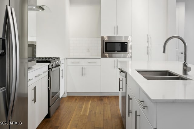 3131 N Central Ave Unit 3009, Phoenix, AZ 85012 - kitchen featuring appliances with stainless steel finishes, a sink, dark wood-type flooring, tasteful backsplash, and white cabinets
