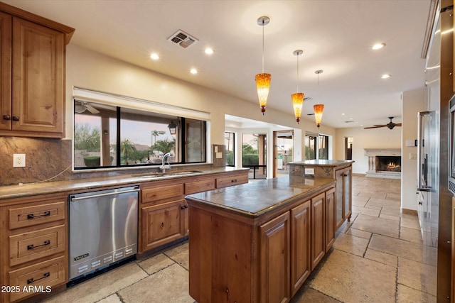 kitchen with dishwasher, stone tile flooring, ceiling fan, recessed lighting, and a sink