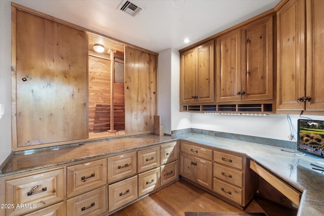 kitchen with wood finished floors, light stone countertops, and recessed lighting