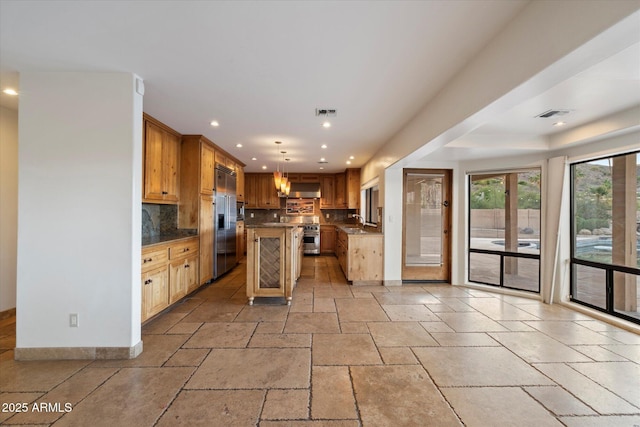 kitchen featuring extractor fan, recessed lighting, stone tile flooring, decorative backsplash, and a center island