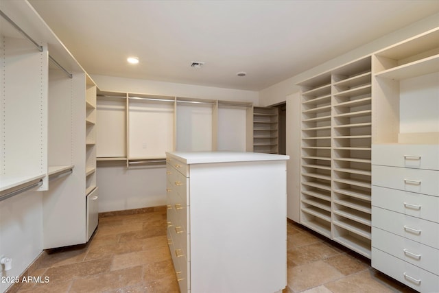 spacious closet featuring stone tile flooring