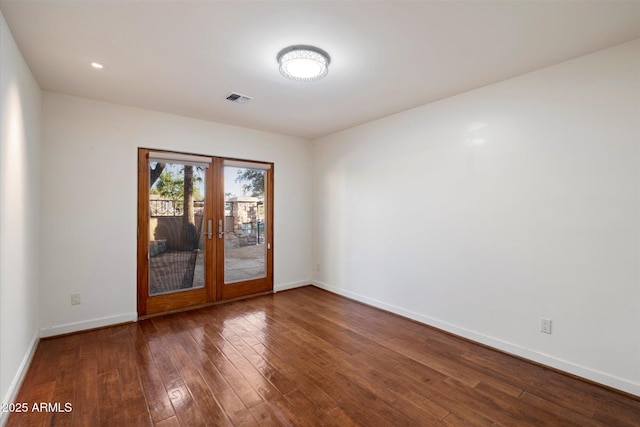 empty room featuring french doors, wood-type flooring, and baseboards