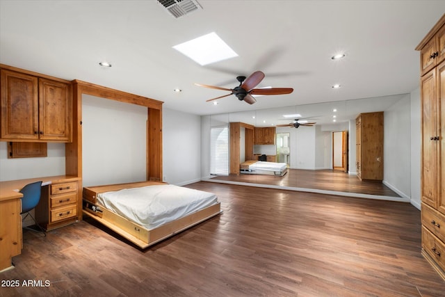 bedroom featuring an office area, recessed lighting, wood finished floors, a skylight, and baseboards