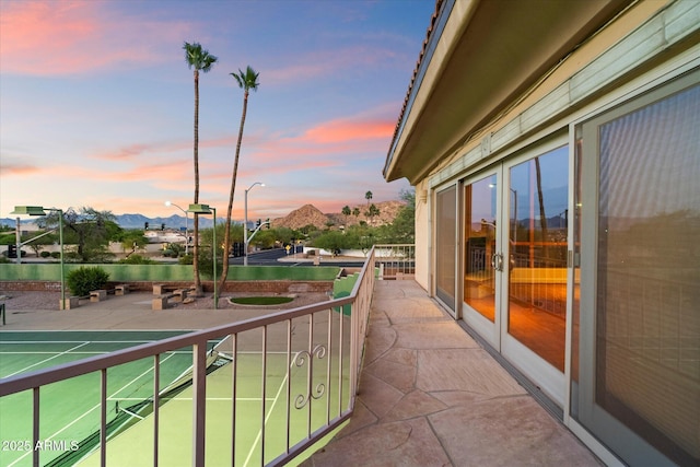 balcony at dusk with a mountain view and french doors