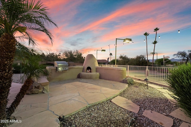 view of patio / terrace featuring exterior kitchen, grilling area, and fence