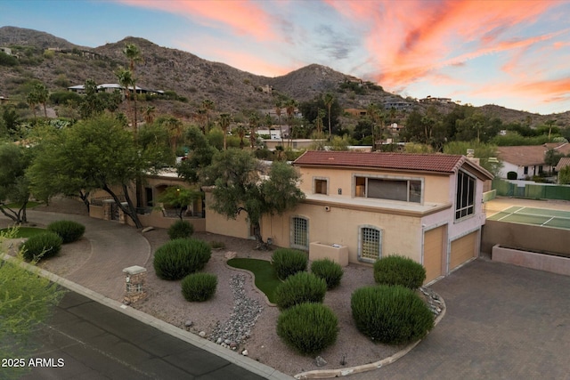view of front of home featuring a tiled roof, a mountain view, and stucco siding