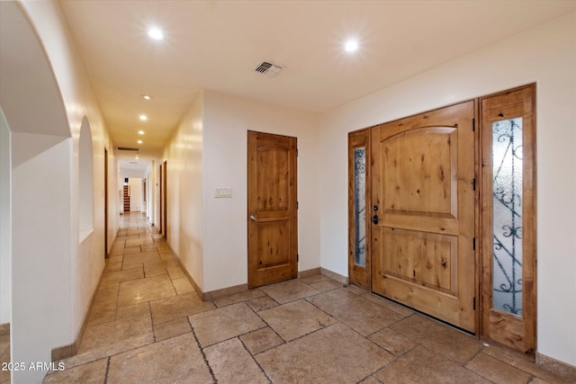 foyer entrance with stone tile flooring, recessed lighting, and baseboards