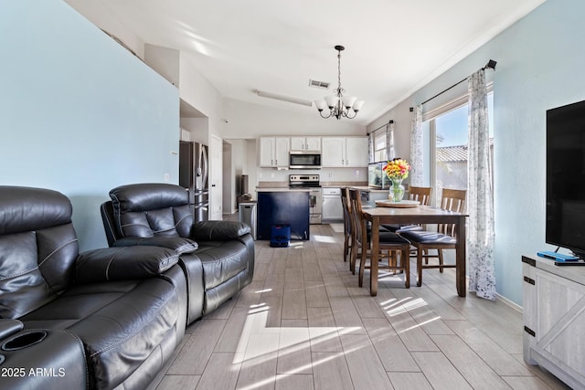 living room featuring lofted ceiling and a chandelier