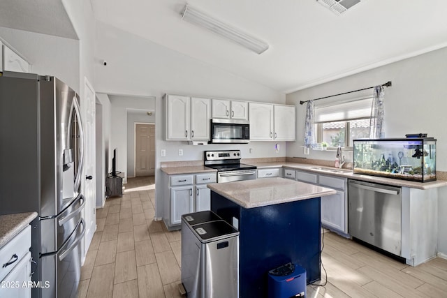 kitchen featuring white cabinetry, stainless steel appliances, sink, and a kitchen island