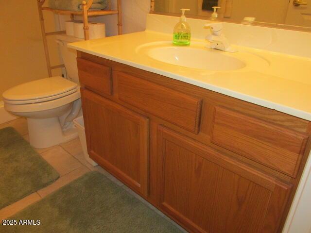 bathroom featuring toilet, tile patterned flooring, and vanity