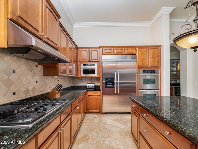 kitchen with crown molding, decorative backsplash, appliances with stainless steel finishes, dark stone counters, and under cabinet range hood