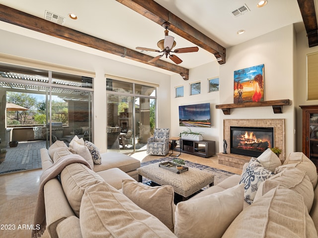 tiled living area with a tiled fireplace, plenty of natural light, and visible vents