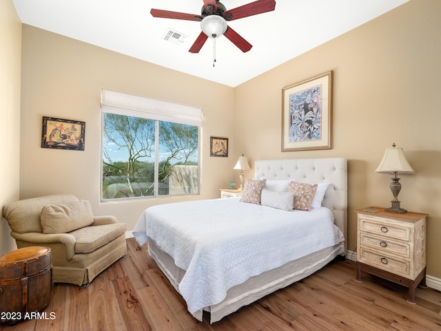 bedroom featuring ceiling fan, wood finished floors, visible vents, and baseboards