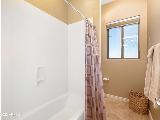 full bath with shower / bath combo, baseboards, and tile patterned floors