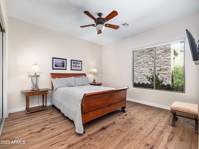 bedroom with baseboards, visible vents, and light wood finished floors