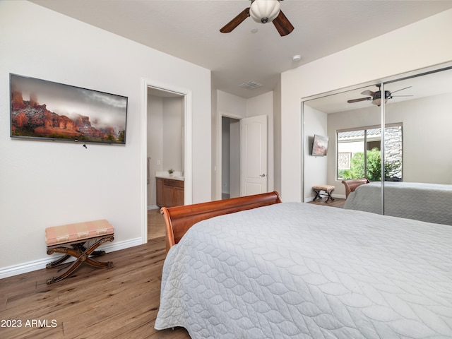 bedroom featuring a closet, visible vents, ceiling fan, wood finished floors, and baseboards