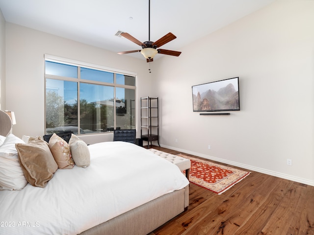 bedroom with visible vents, ceiling fan, baseboards, and wood finished floors