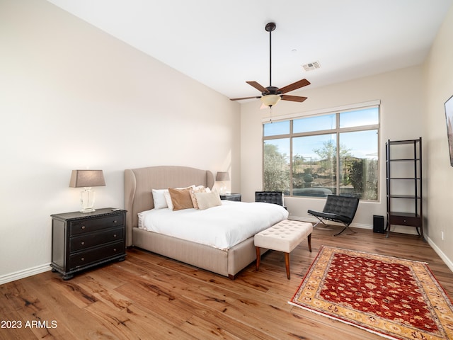 bedroom with a ceiling fan, light wood-style flooring, visible vents, and baseboards