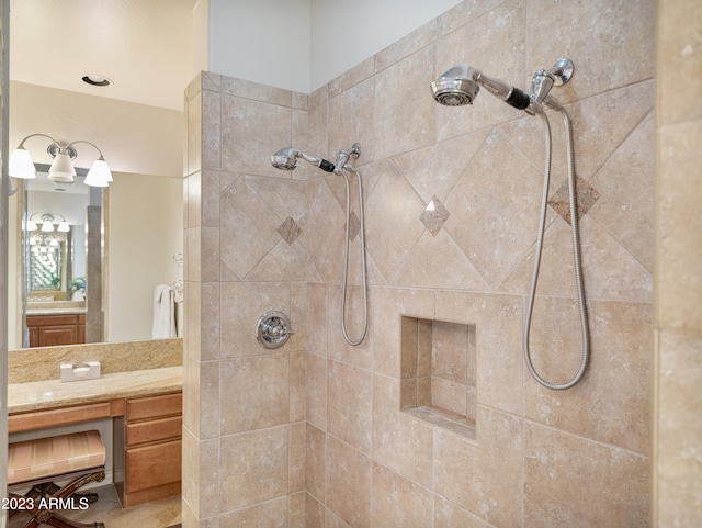 bathroom with a tile shower and vanity