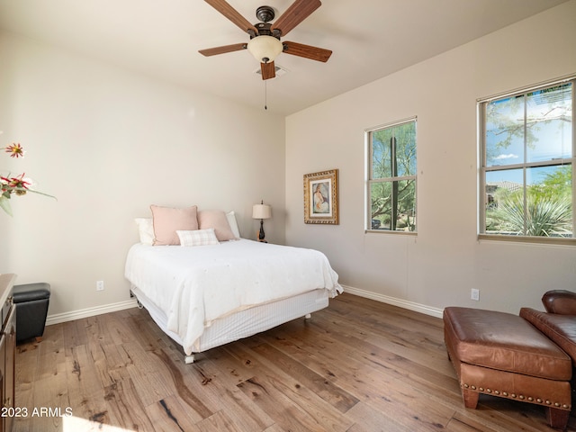 bedroom with ceiling fan, baseboards, and wood finished floors