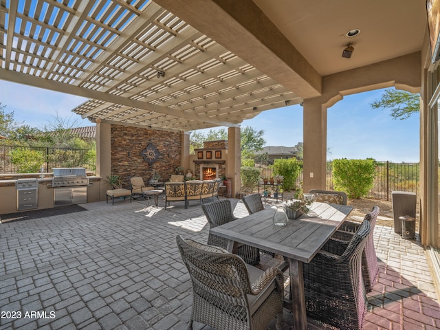 view of patio / terrace featuring an outdoor stone fireplace, outdoor dining area, area for grilling, a grill, and fence