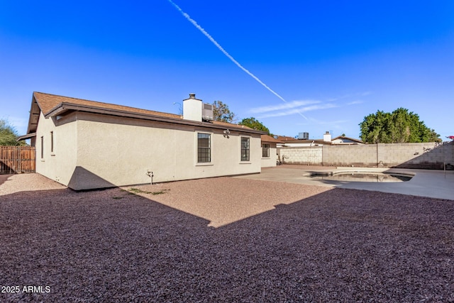 back of house with a patio area and a swimming pool