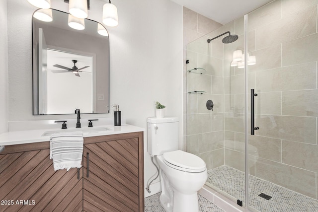 bathroom featuring vanity, ceiling fan, toilet, and a shower with door