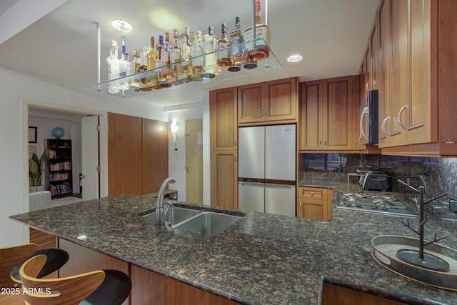 kitchen with appliances with stainless steel finishes, sink, and kitchen peninsula