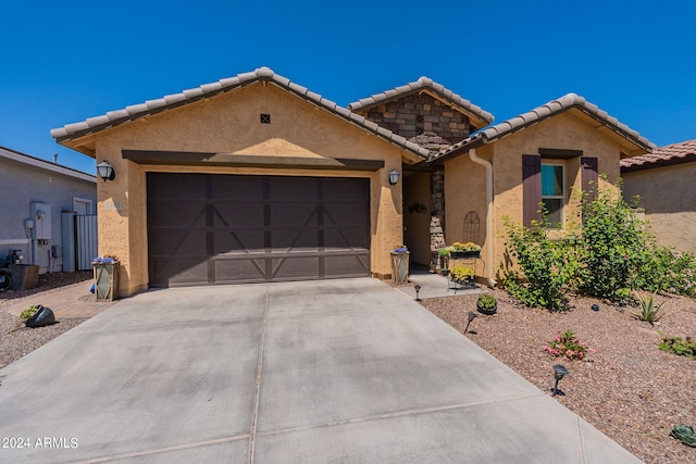 ranch-style house with an attached garage, a tile roof, concrete driveway, stone siding, and stucco siding