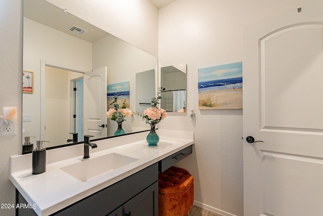 bathroom with visible vents, vanity, and baseboards