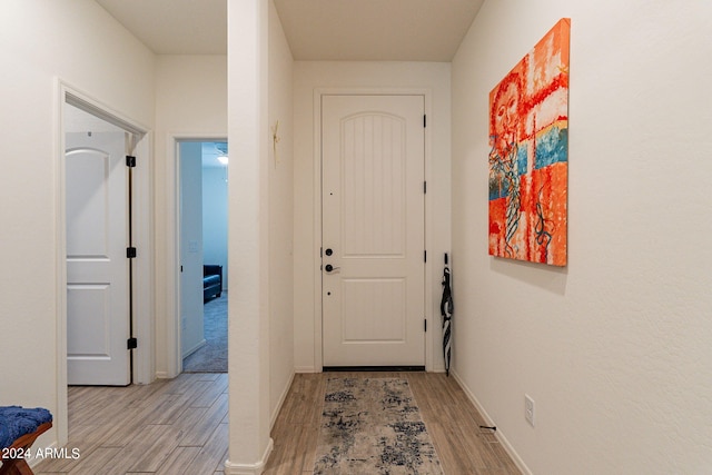 entryway with light wood-type flooring and baseboards