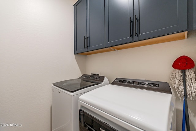 laundry room featuring washing machine and clothes dryer and cabinet space