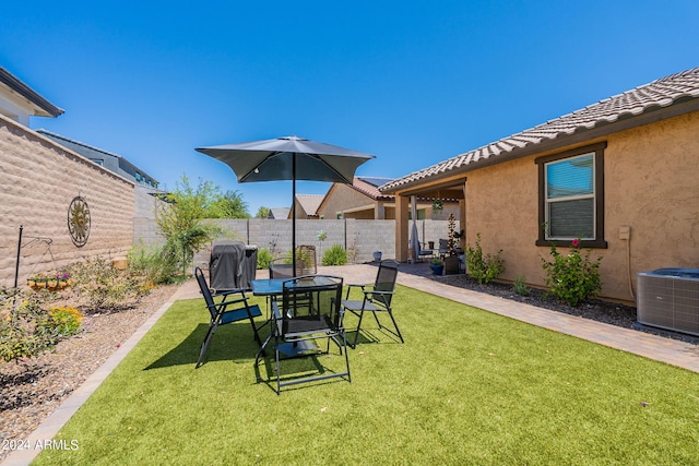 view of yard with a fenced backyard and central AC unit