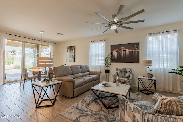 living room with ceiling fan, wood finished floors, and visible vents