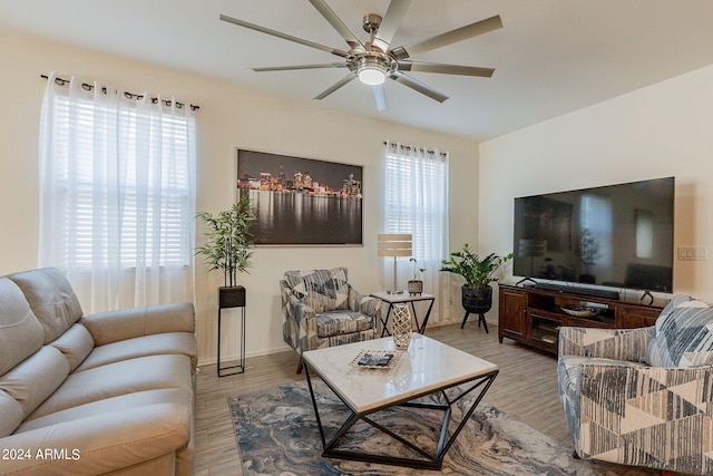 living area with a ceiling fan and wood finished floors