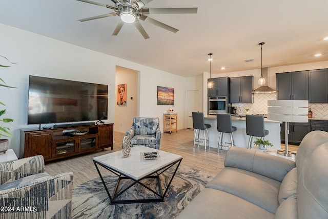 living area with recessed lighting, visible vents, ceiling fan, and light wood-style flooring