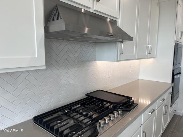 kitchen with white cabinets, backsplash, and appliances with stainless steel finishes