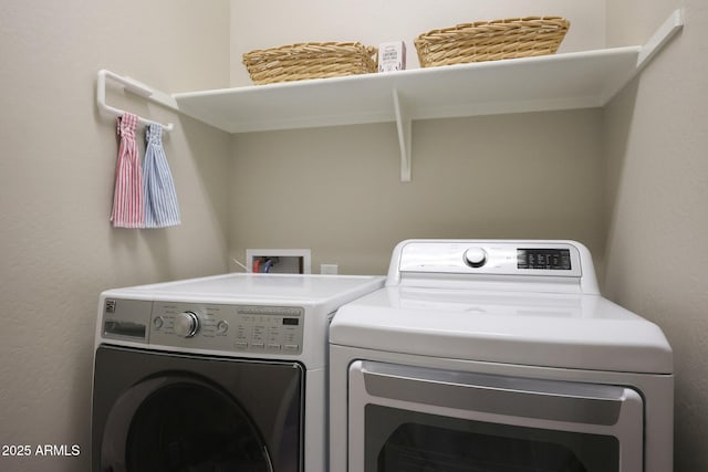 laundry area with a textured wall, independent washer and dryer, and laundry area
