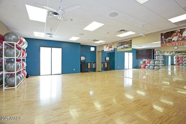 exercise area with visible vents, a drop ceiling, and ceiling fan
