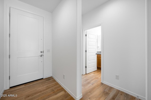 entryway with baseboards and light wood-style flooring