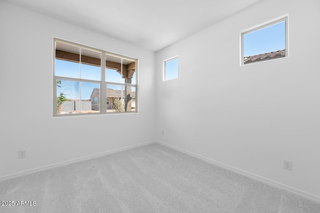 spare room featuring carpet flooring and baseboards