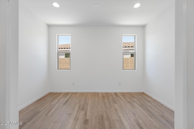 spare room featuring recessed lighting, light wood-style flooring, and baseboards