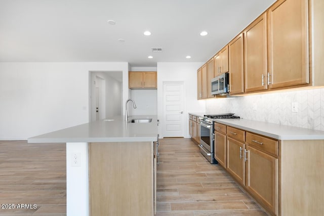 kitchen with a sink, stainless steel appliances, light wood-style flooring, visible vents, and recessed lighting