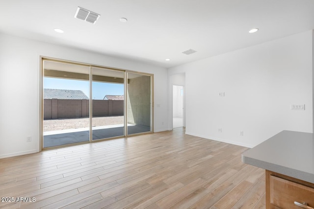 empty room with baseboards, visible vents, recessed lighting, and light wood-style floors