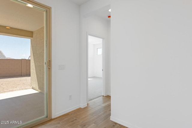 hallway with baseboards and wood finished floors