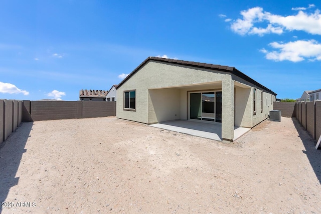 back of house featuring a fenced backyard, central AC unit, a patio, and stucco siding
