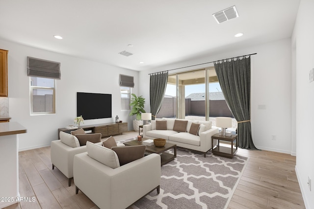living room with baseboards, visible vents, recessed lighting, and light wood-style floors
